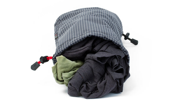 A Travel Laundry Stuff Sack showing dirty clothes in one side.